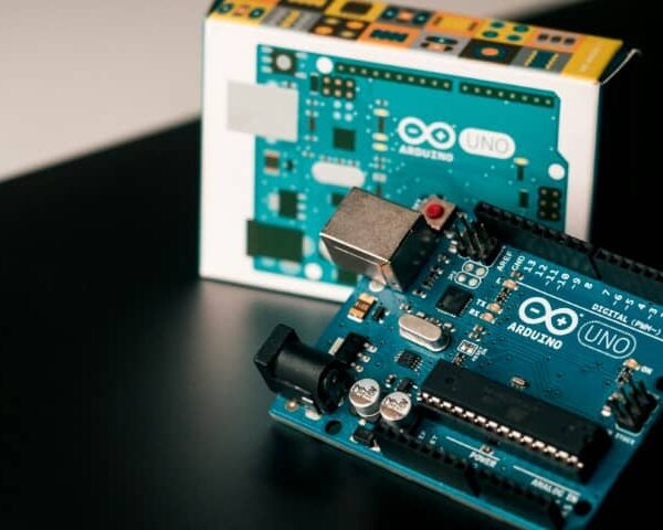 An Arduino UNO board displayed next to its packaging box.