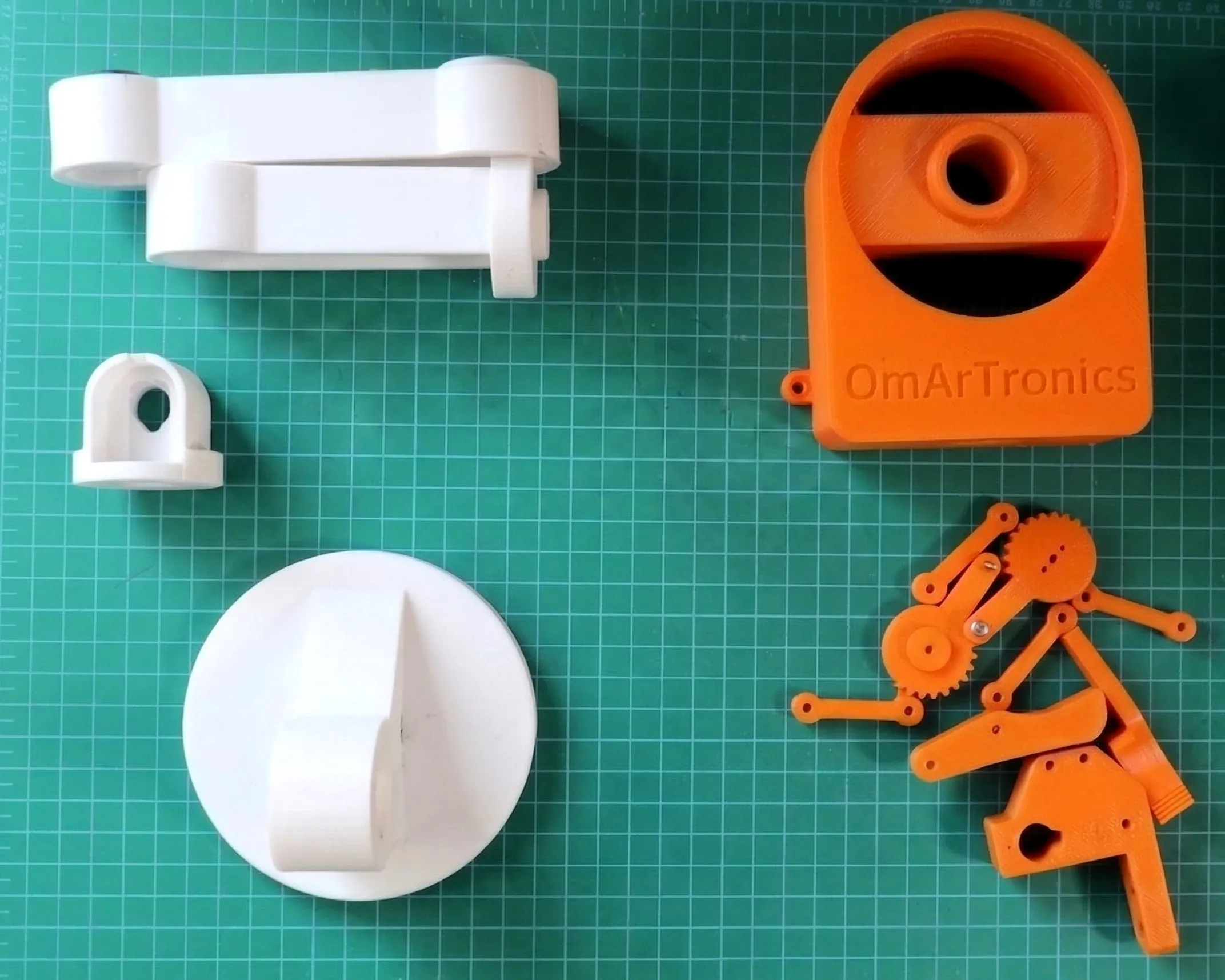 Two-color printed parts — white structural links, orange base and gripper