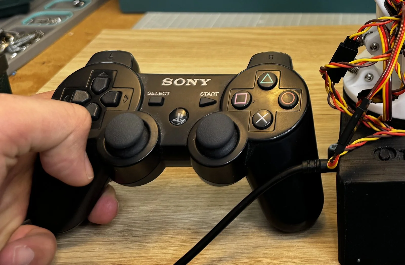Front view of a genuine Sony DualShock 3 controller showing the PS button, both analog sticks and the four face buttons